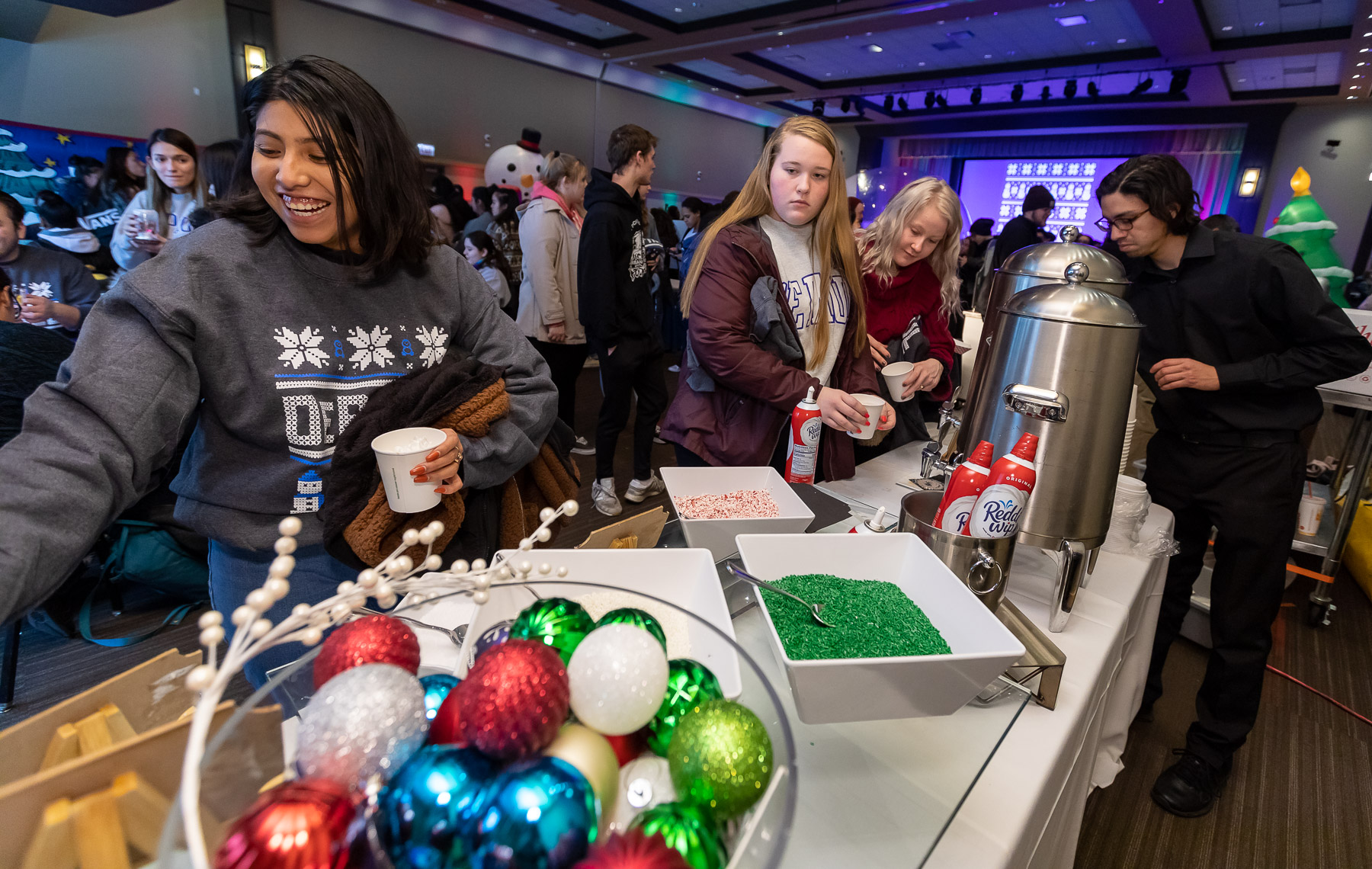 Students fill cups of hot cocoa with sweet treats. (DePaul University/Jeff Carrion)